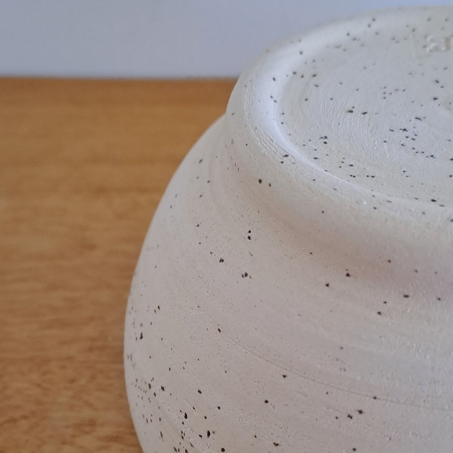 Close-up of a speckled ceramic bowl on a wooden surface