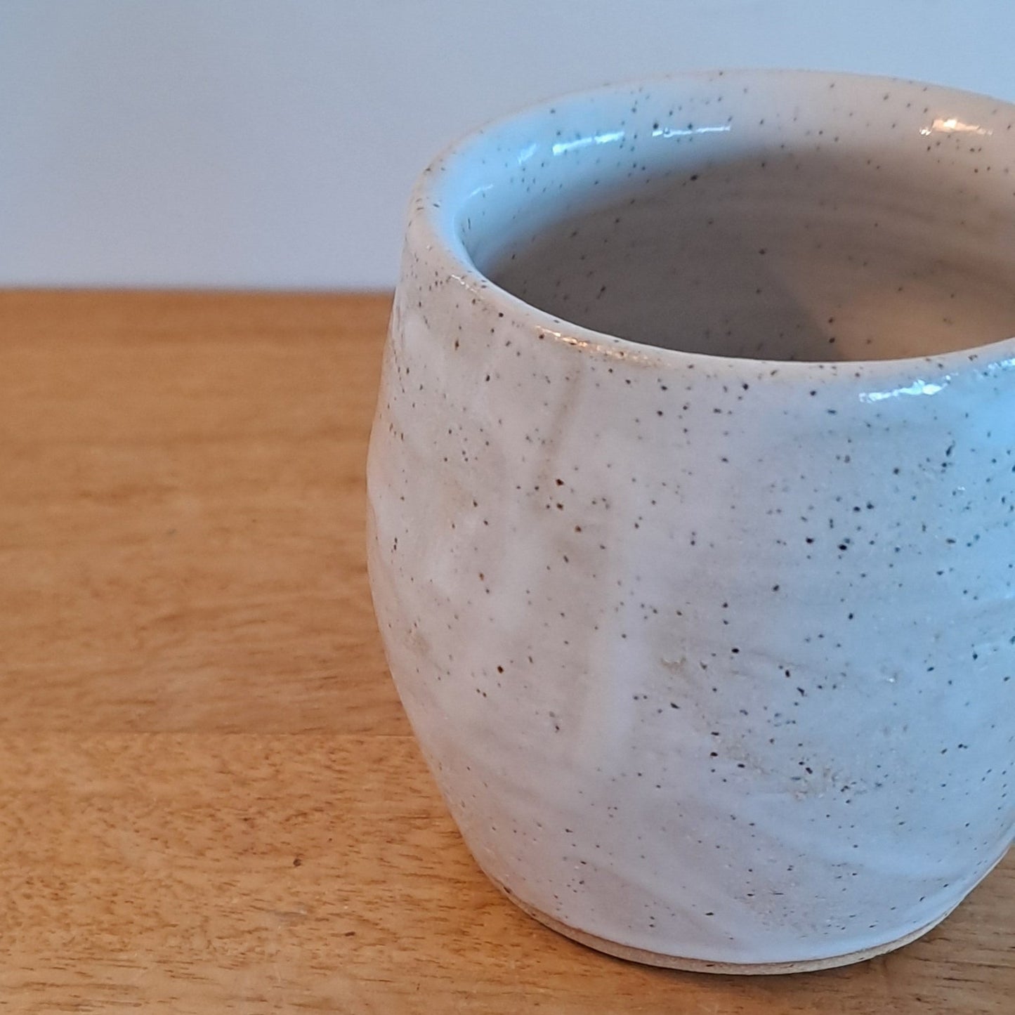 Ceramic cup on a wooden surface with a white background