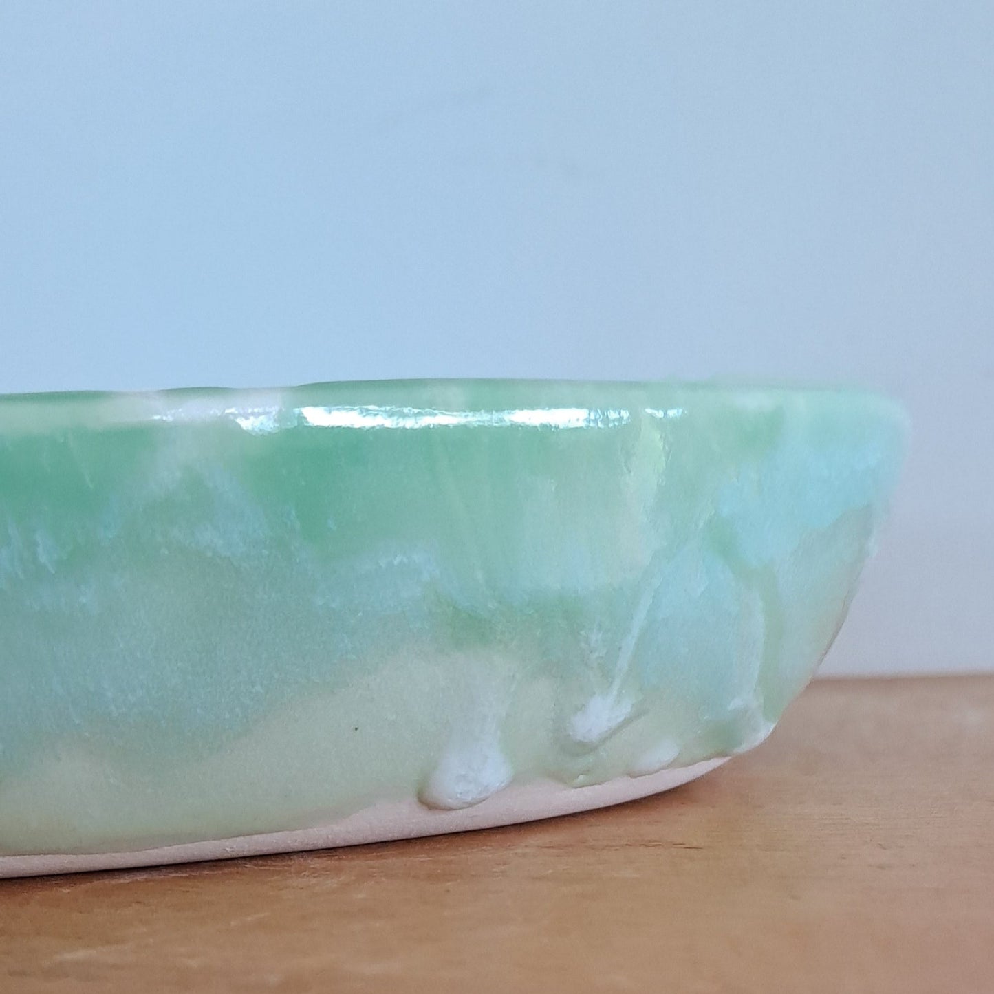 Green ceramic platter on a wooden surface with a white background