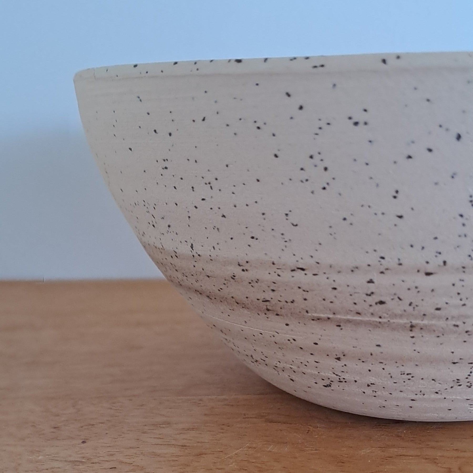 Close-up of a textured ceramic bowl against a neutral background