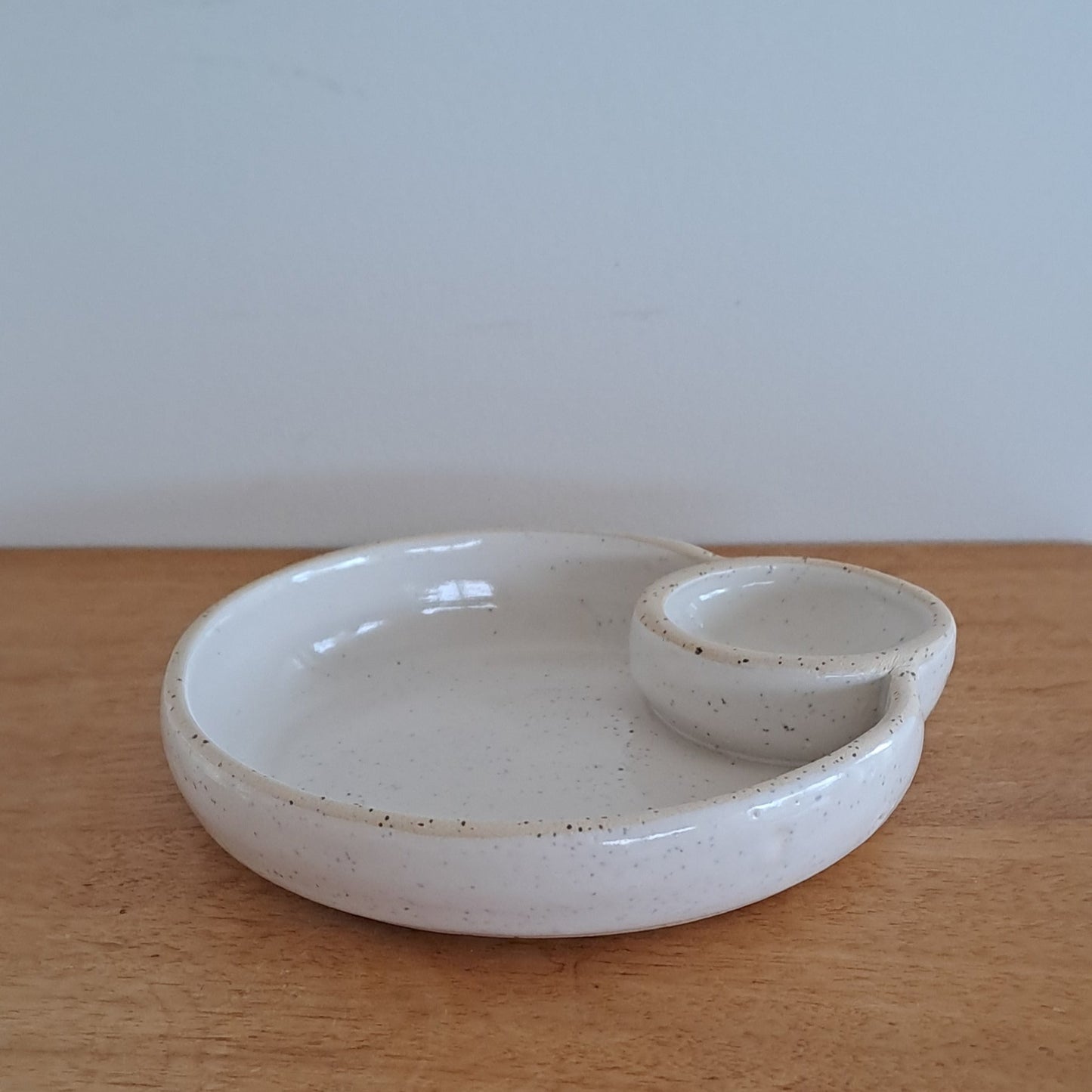 White ceramic dish on a wooden surface with a light gray background