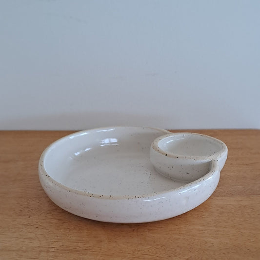White ceramic dish on a wooden surface with a light gray background