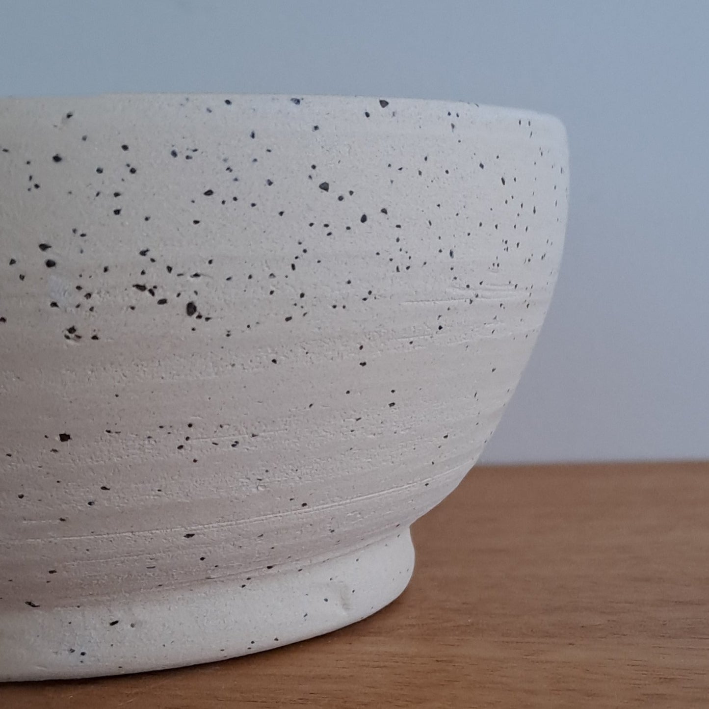 Close-up of a white textured bowl against a wooden surface