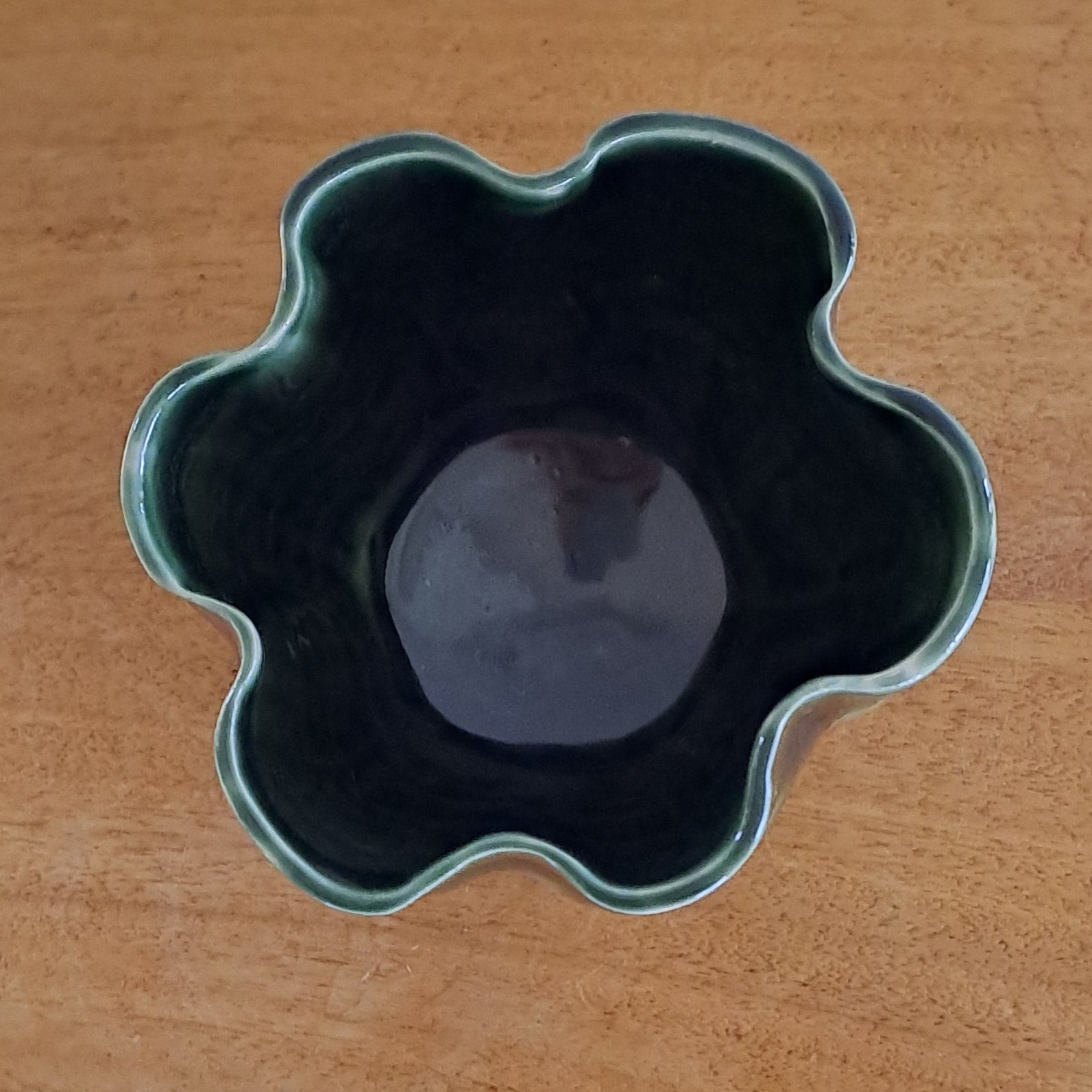 Flower-shaped vase on a wooden surface