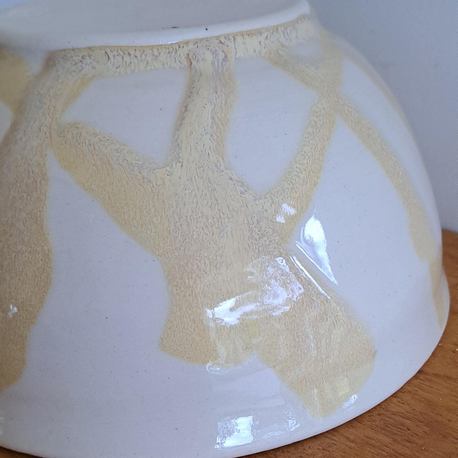 Ceramic bowl with gold leaf design on a wooden surface