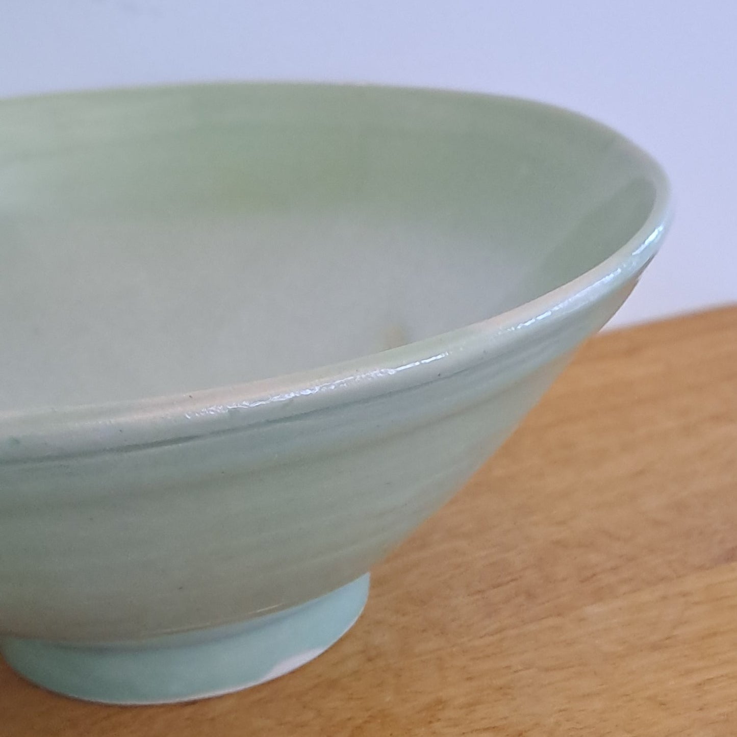 Light green ceramic bowl on a wooden surface