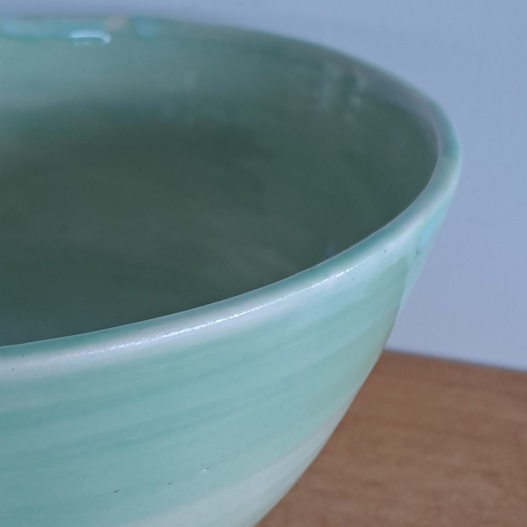 Green ceramic bowl on a wooden surface