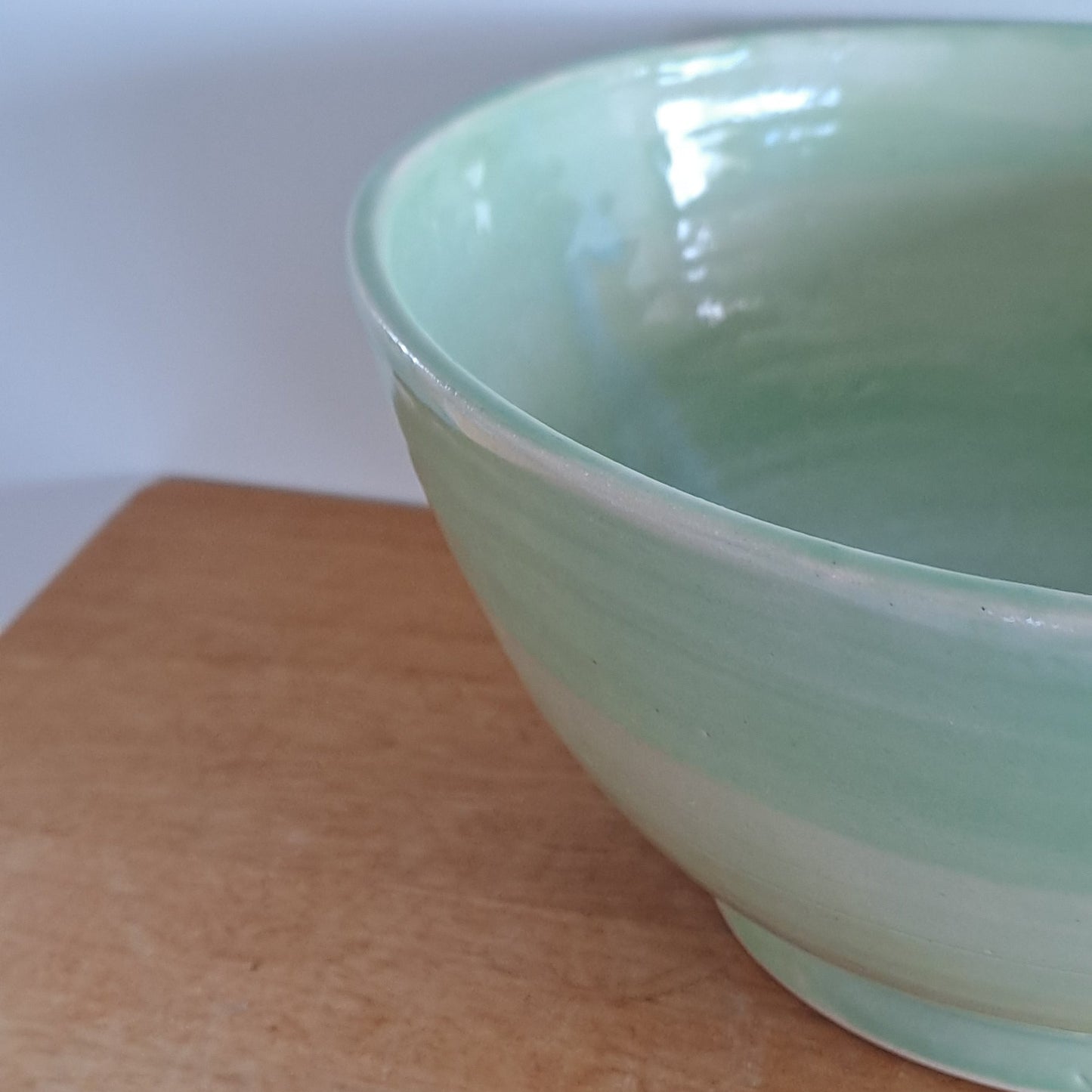 Green bowl on a wooden surface with a white background