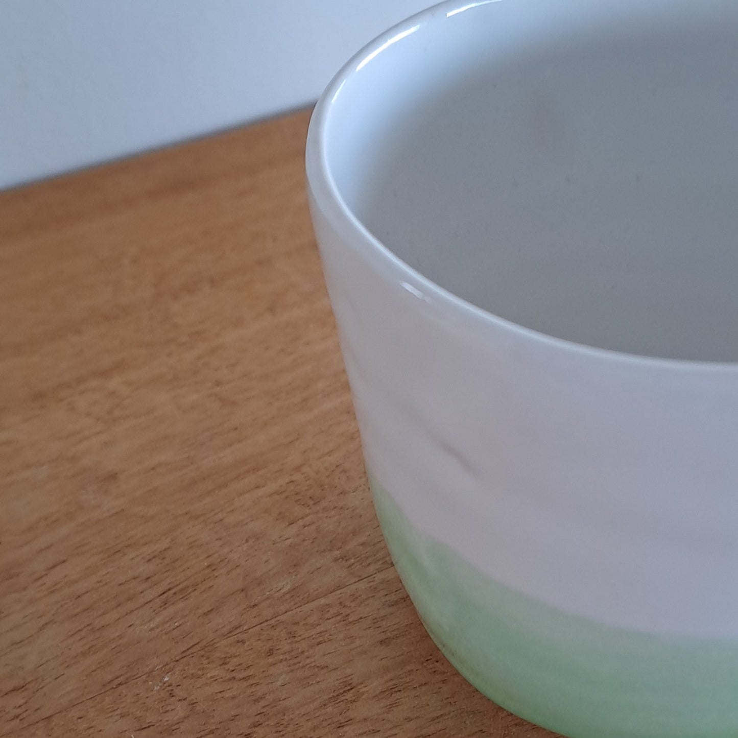 Green cup on a wooden surface
