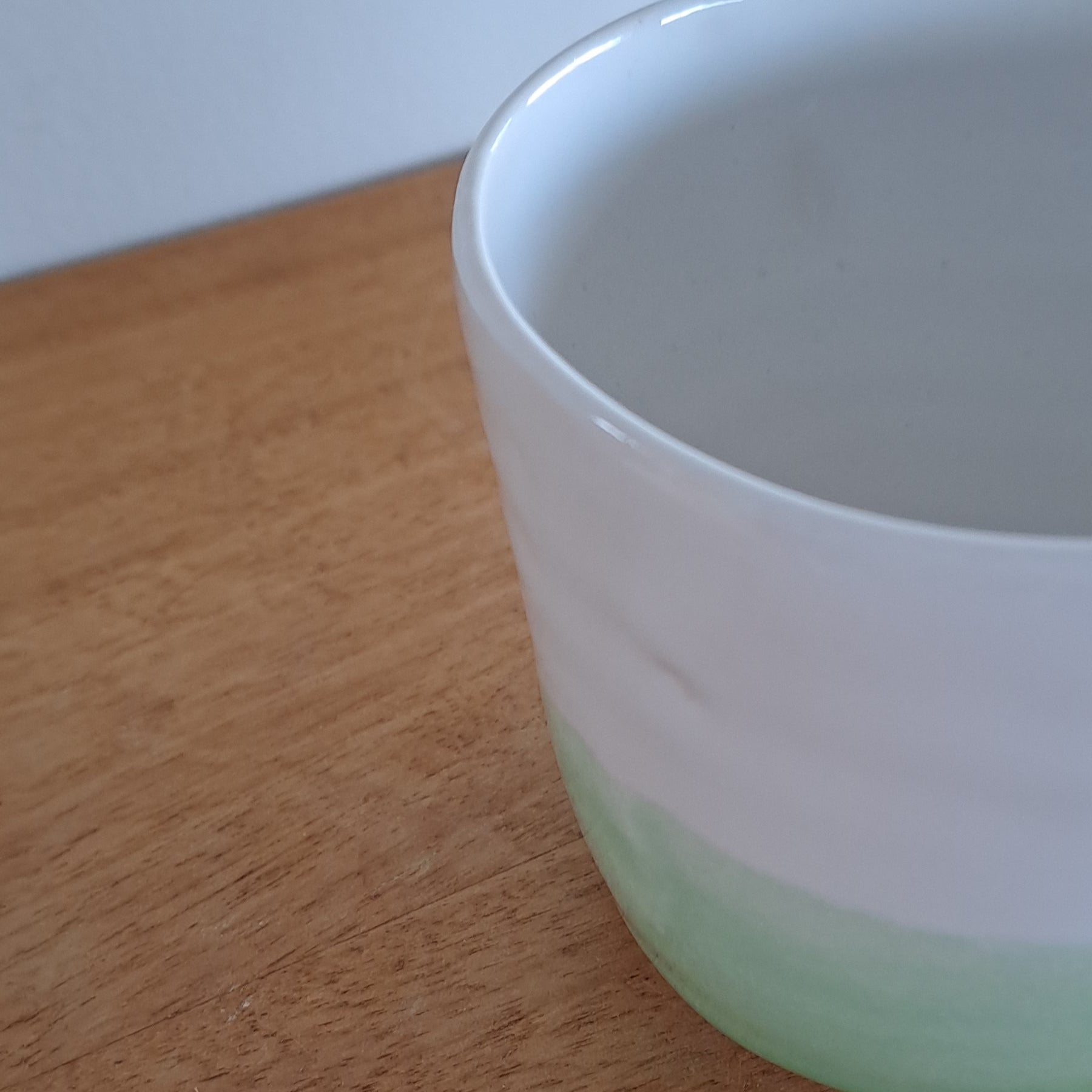 Green cup on a wooden surface