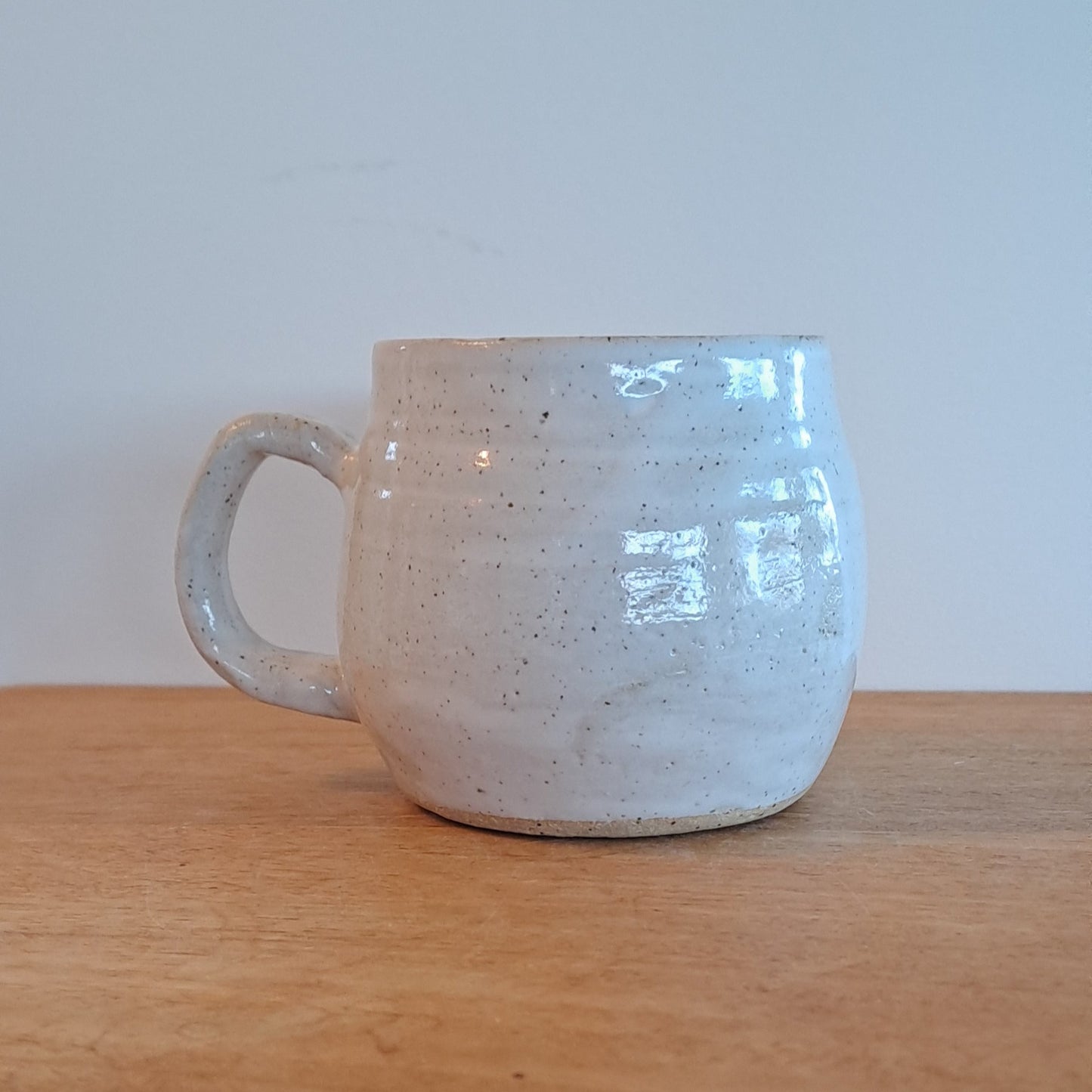 Ceramic mug with textured surface attached to a wooden surface