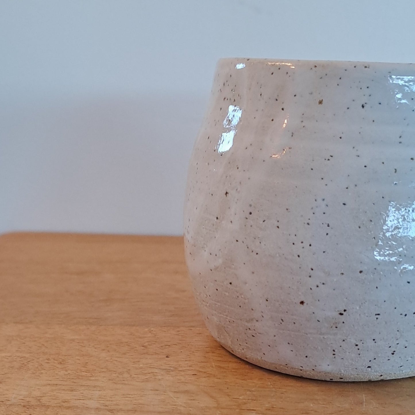 Close-up of a wooden surface with a white ceramic object on top