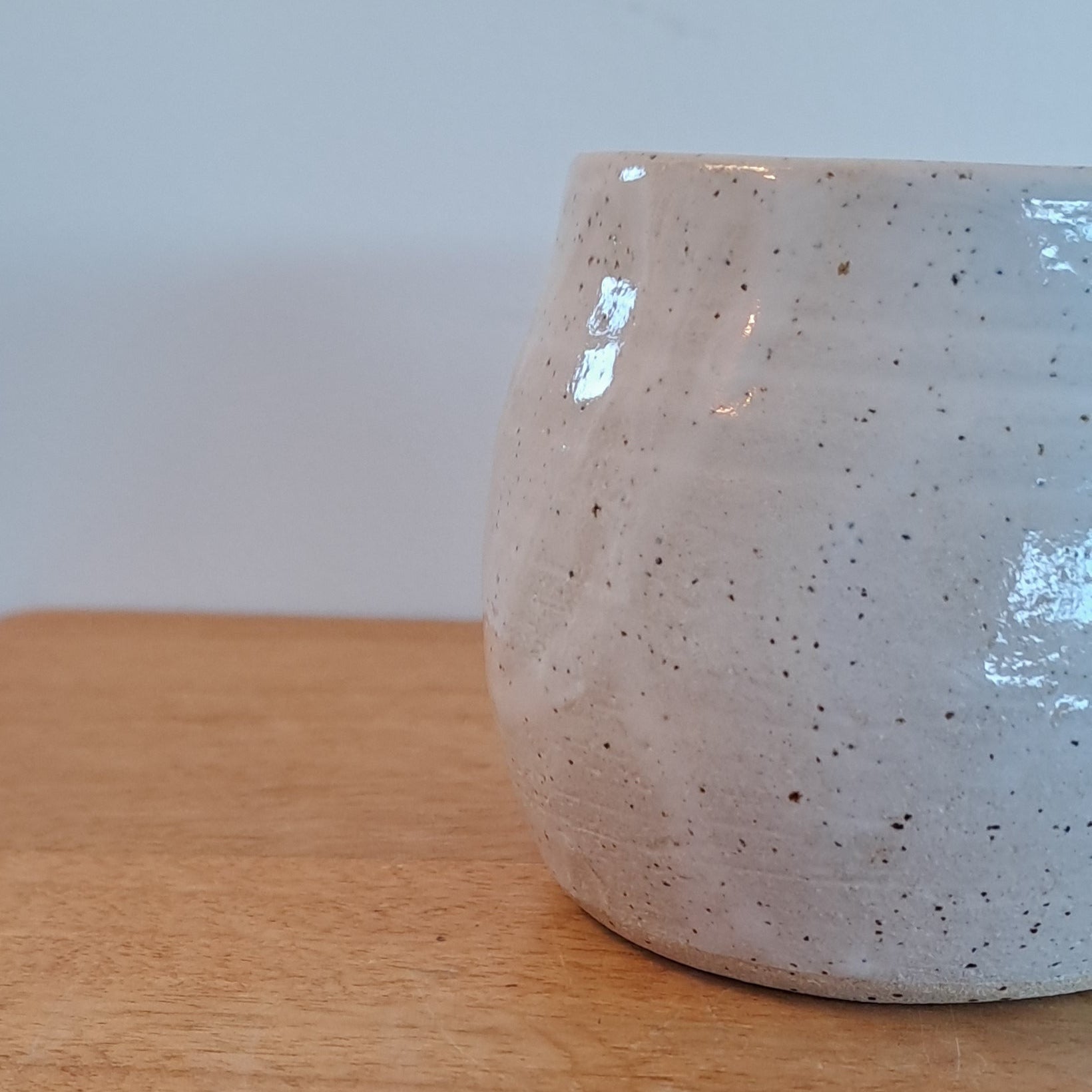 Close-up of a wooden surface with a white ceramic object on top
