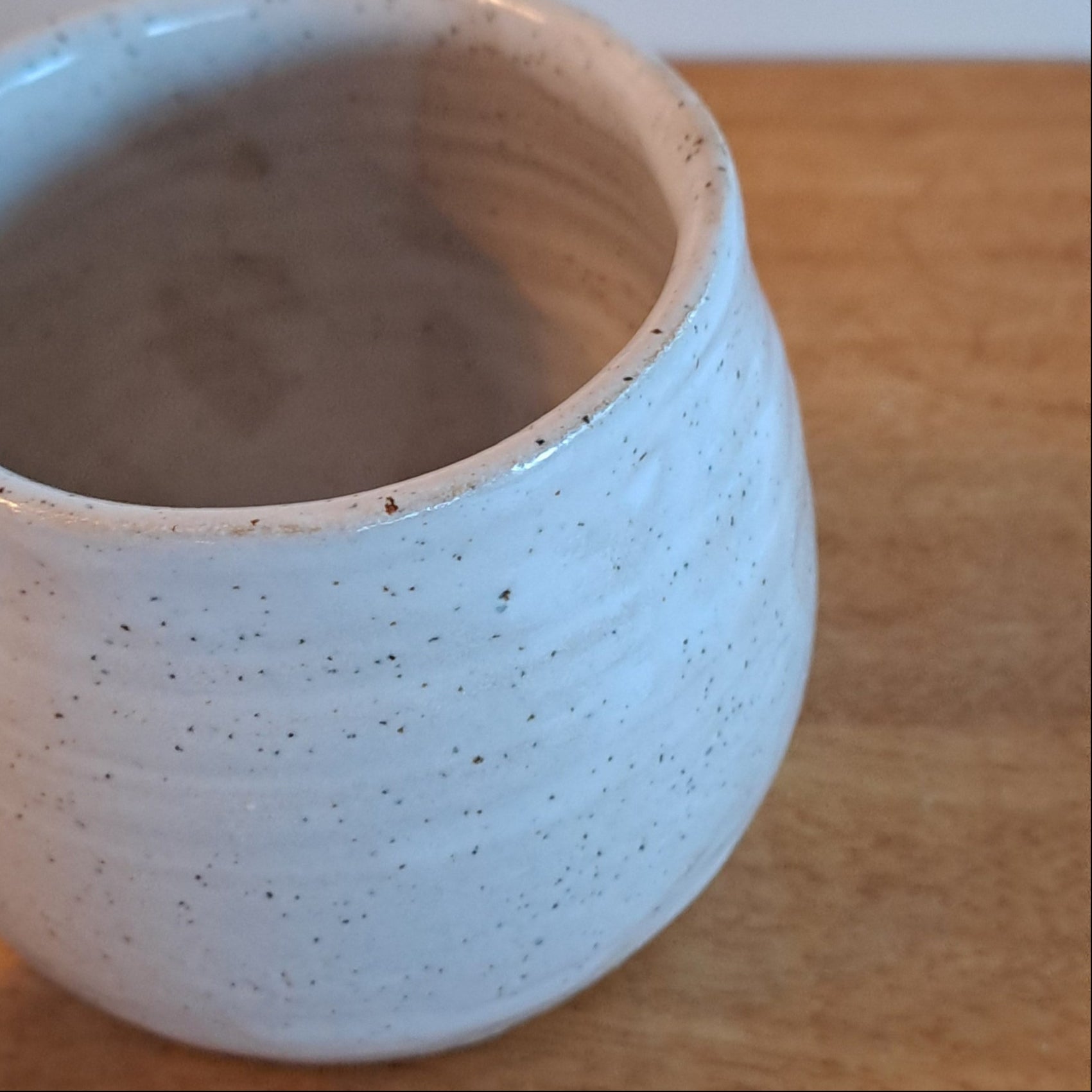 White ceramic mug against a wooden background