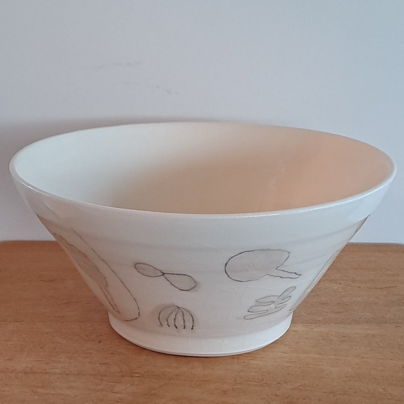 White bowl with simple design on a wooden surface