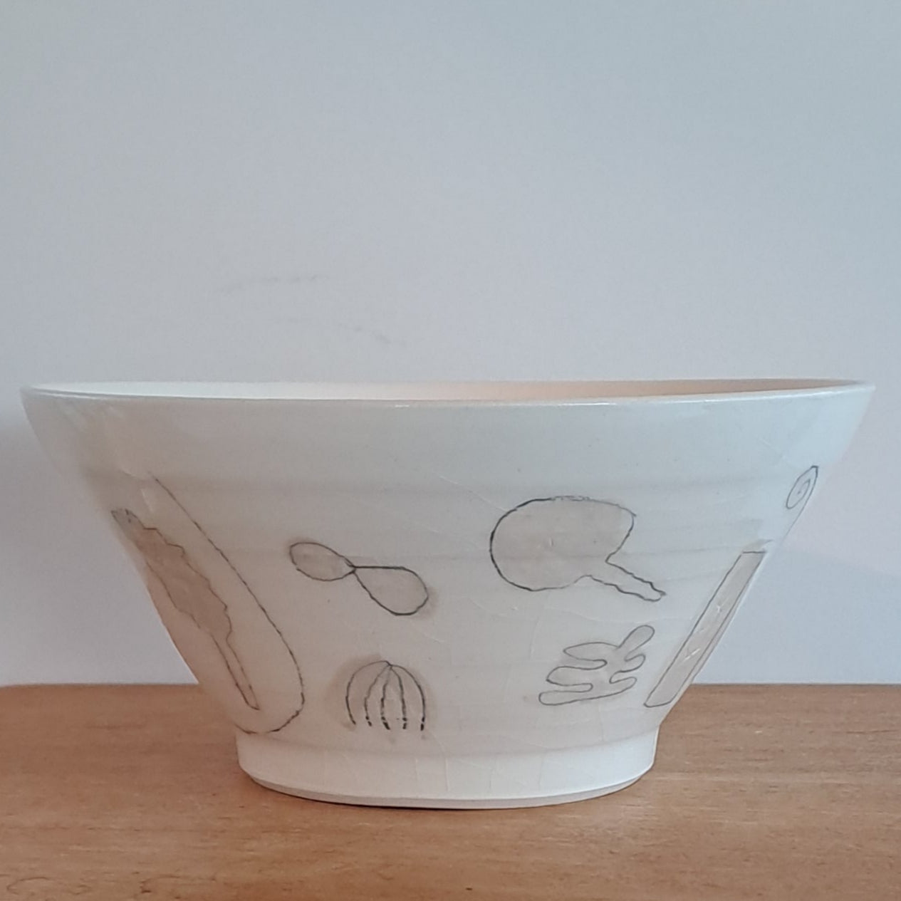 White bowl with simple design on a wooden surface