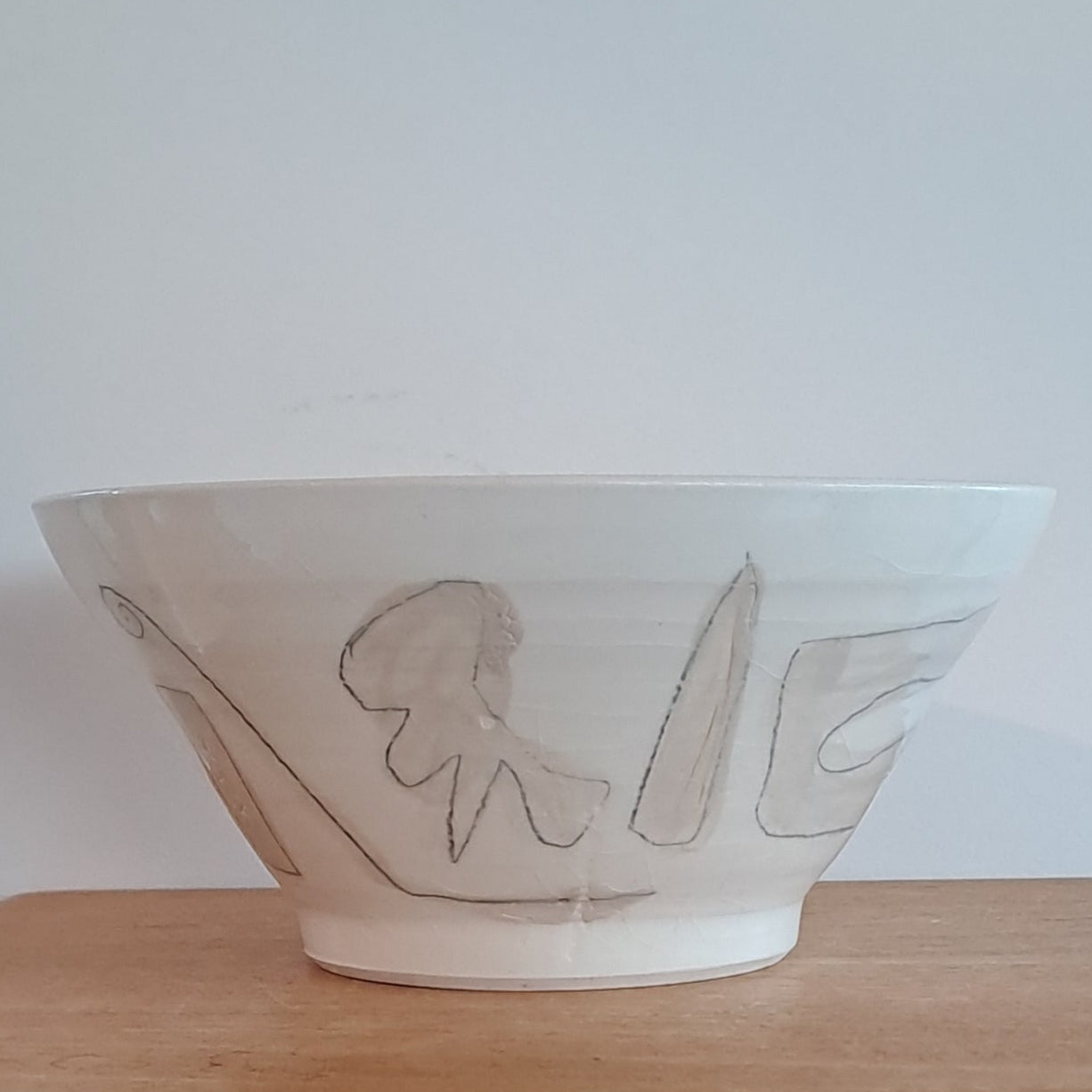 White bowl with simple design on a wooden surface