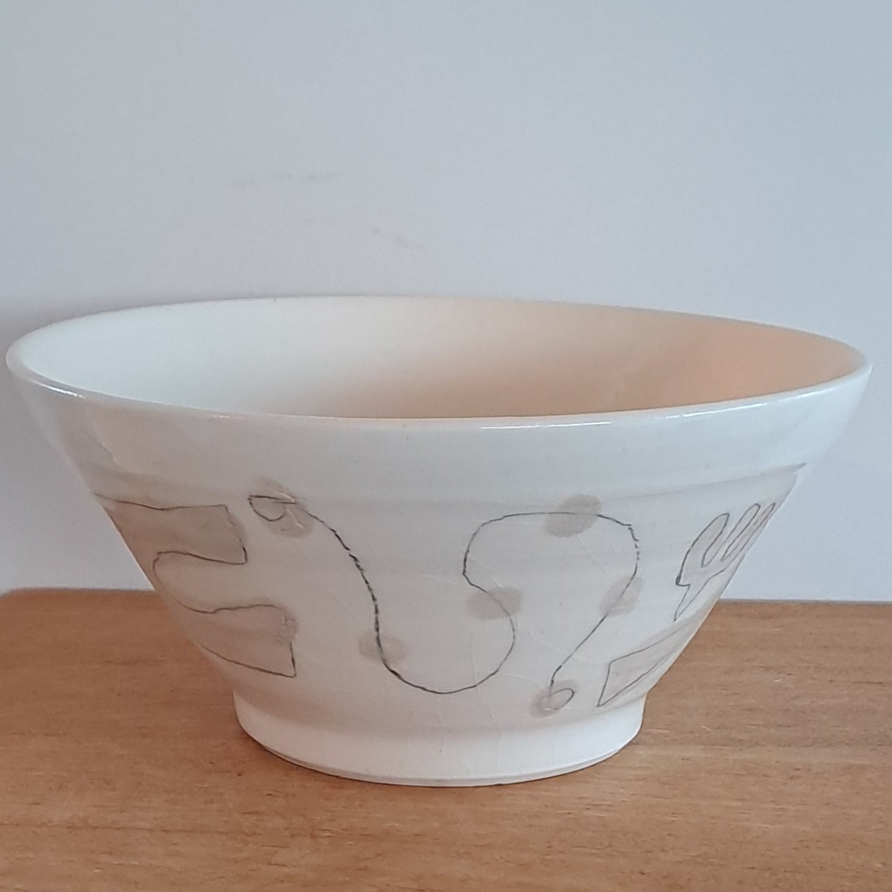 White bowl with simple design on a wooden surface