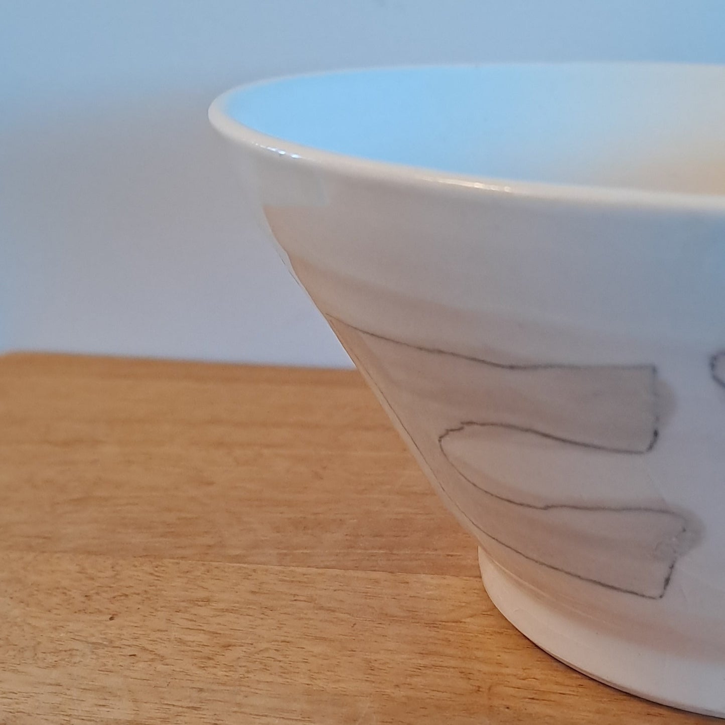 White bowl with simple design on a wooden surface