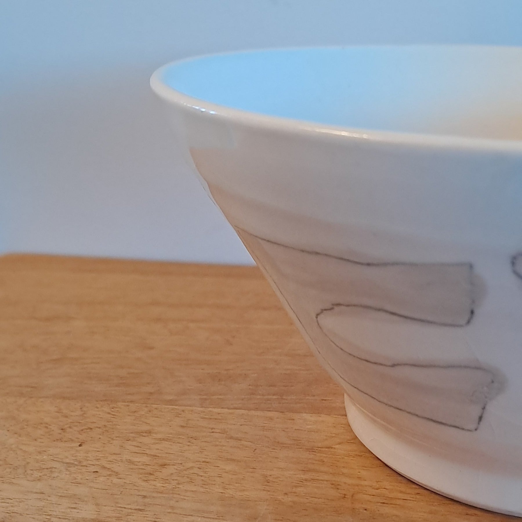 White bowl with simple design on a wooden surface