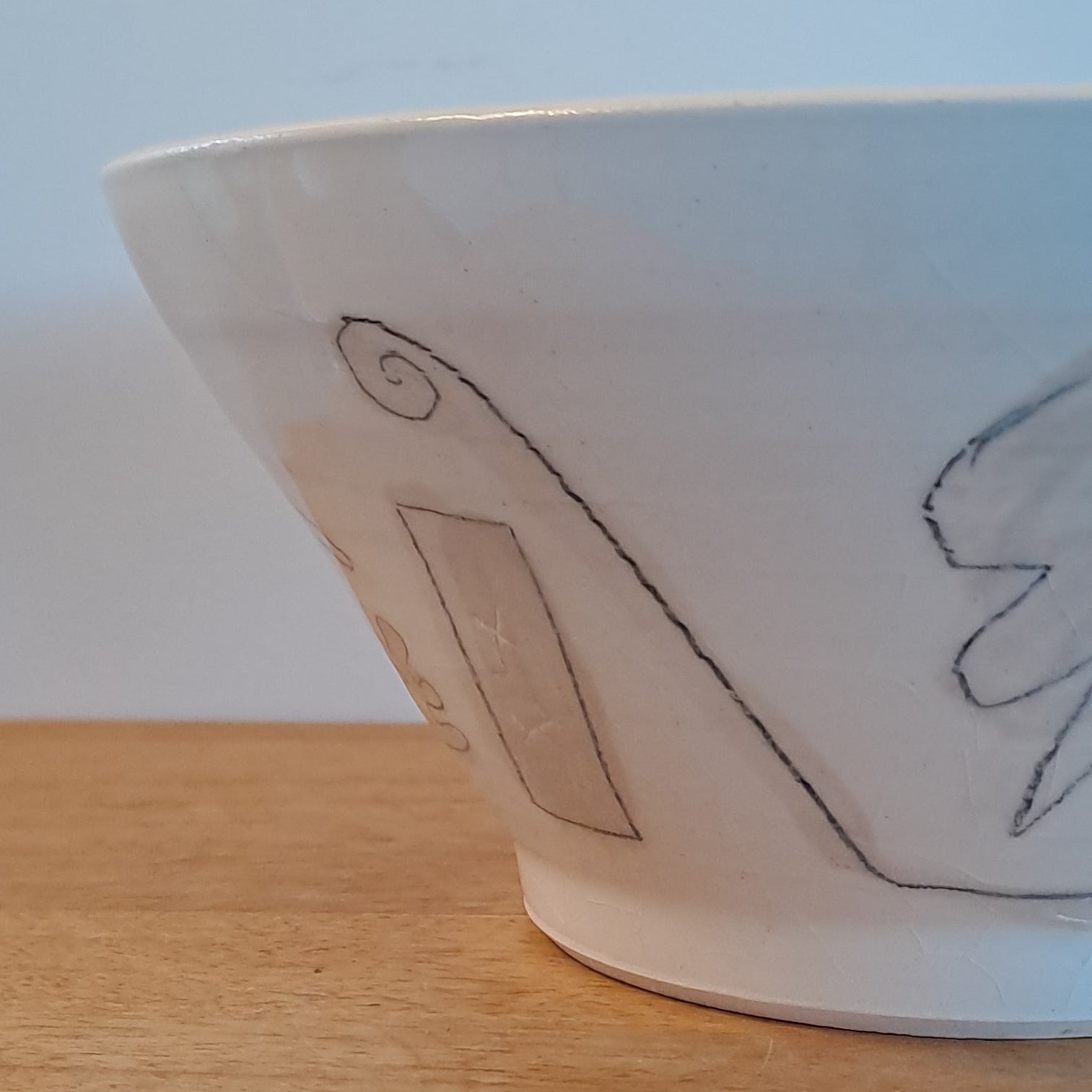 White bowl with simple design on a wooden surface