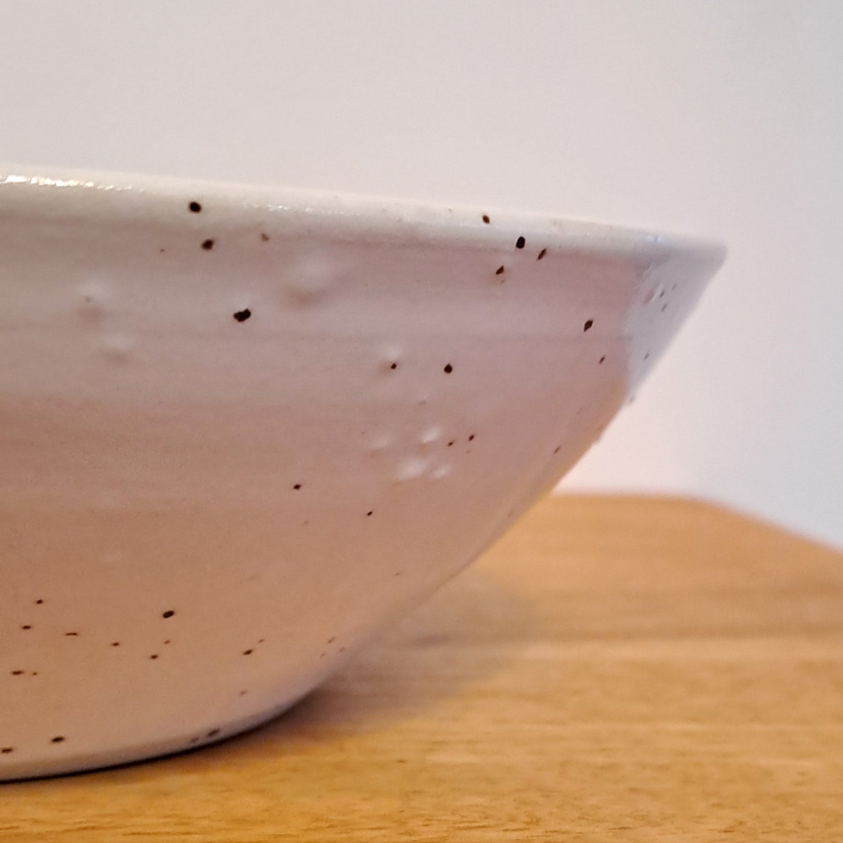 Close-up of a white textured bowl on a light background