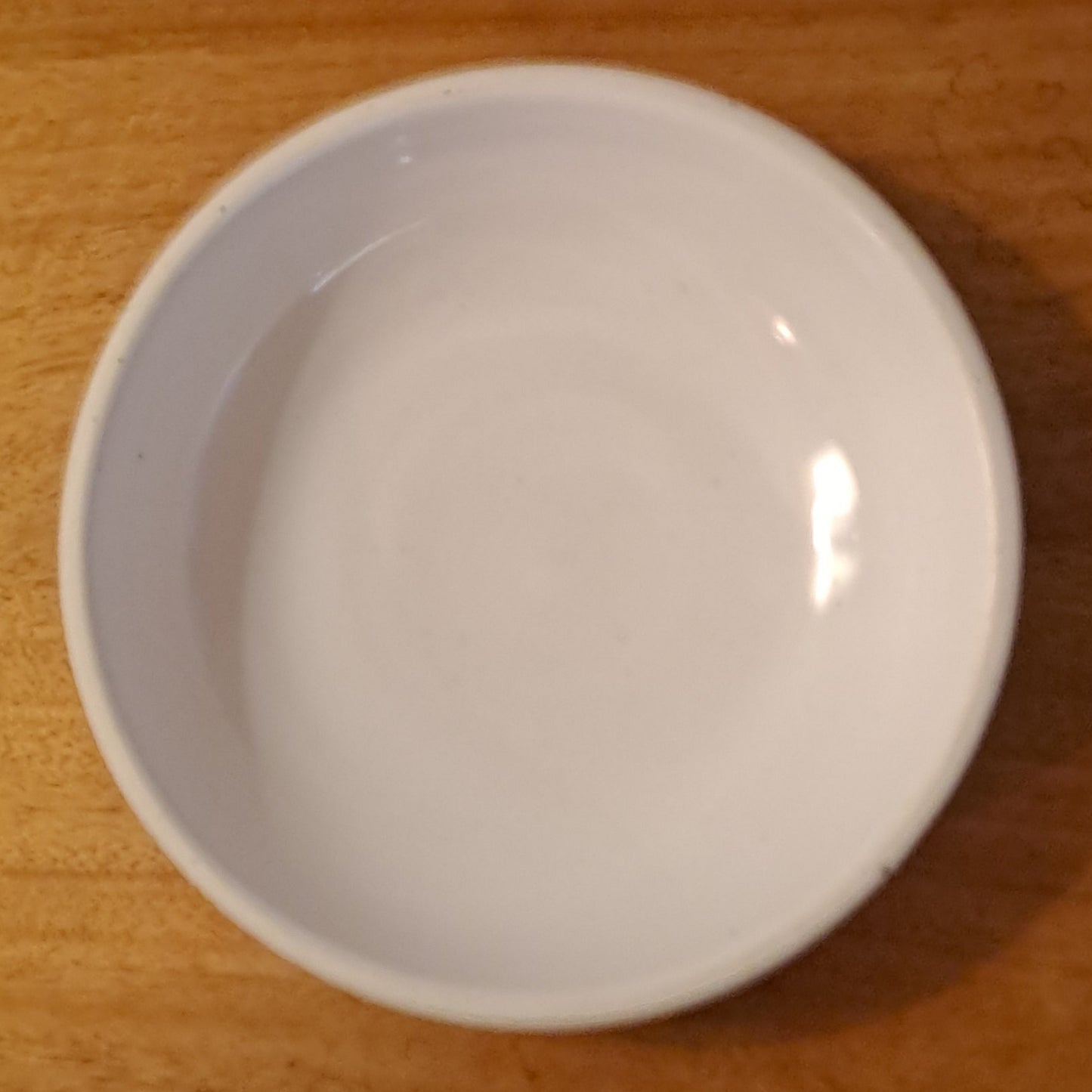 White bowl on a wooden surface with a neutral background