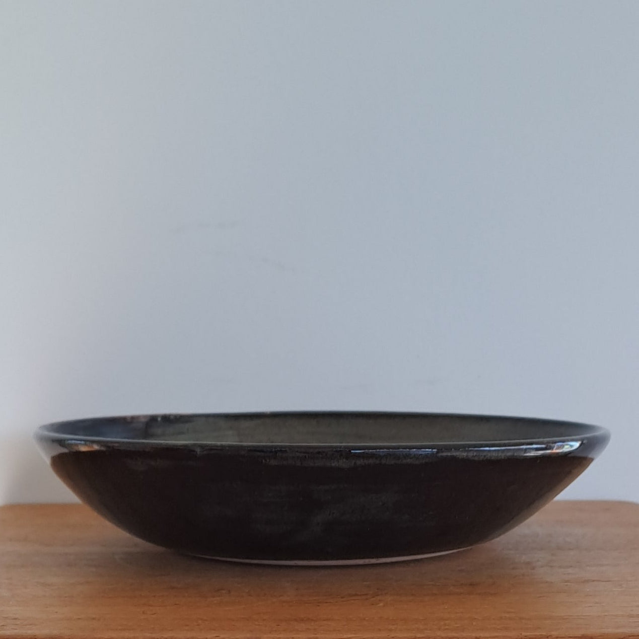 Wooden stool with a black bowl on a white background