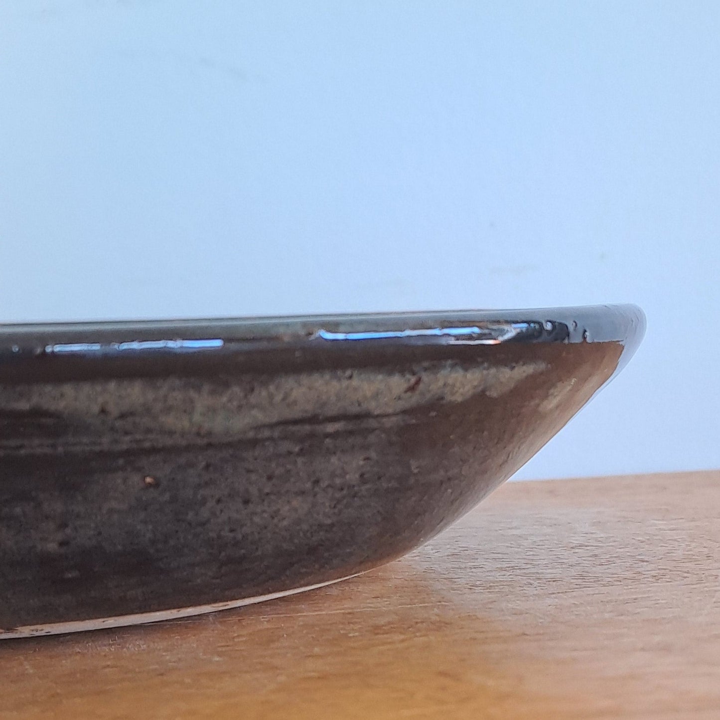 Close-up of a wooden surface with a black bowl