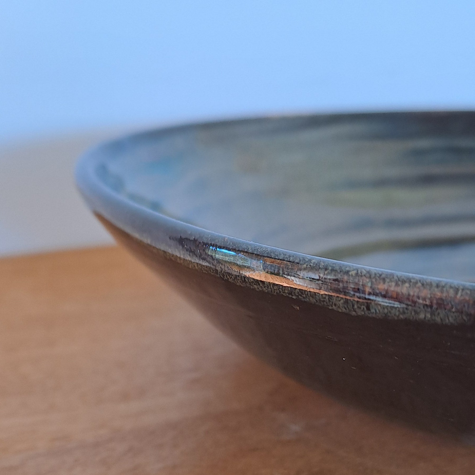 Close-up of a wooden surface with a black bowl on top