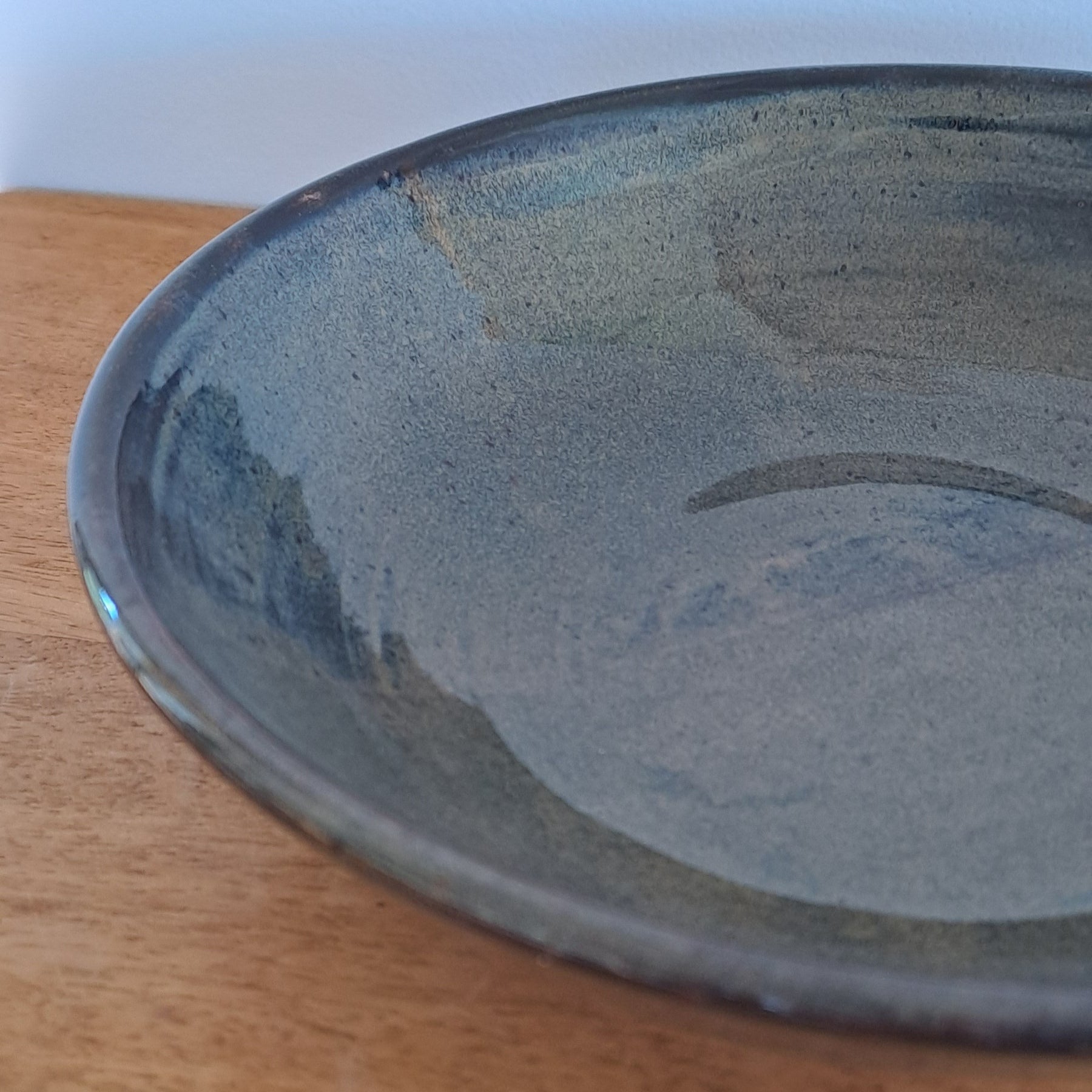Blue black ceramic plate on a wooden surface