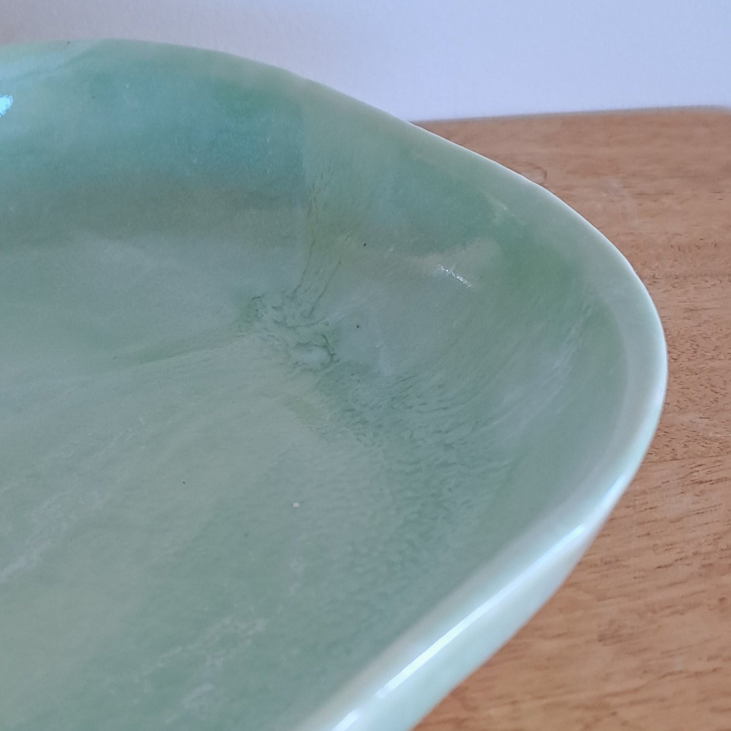 Light green ceramic dish on a wooden surface
