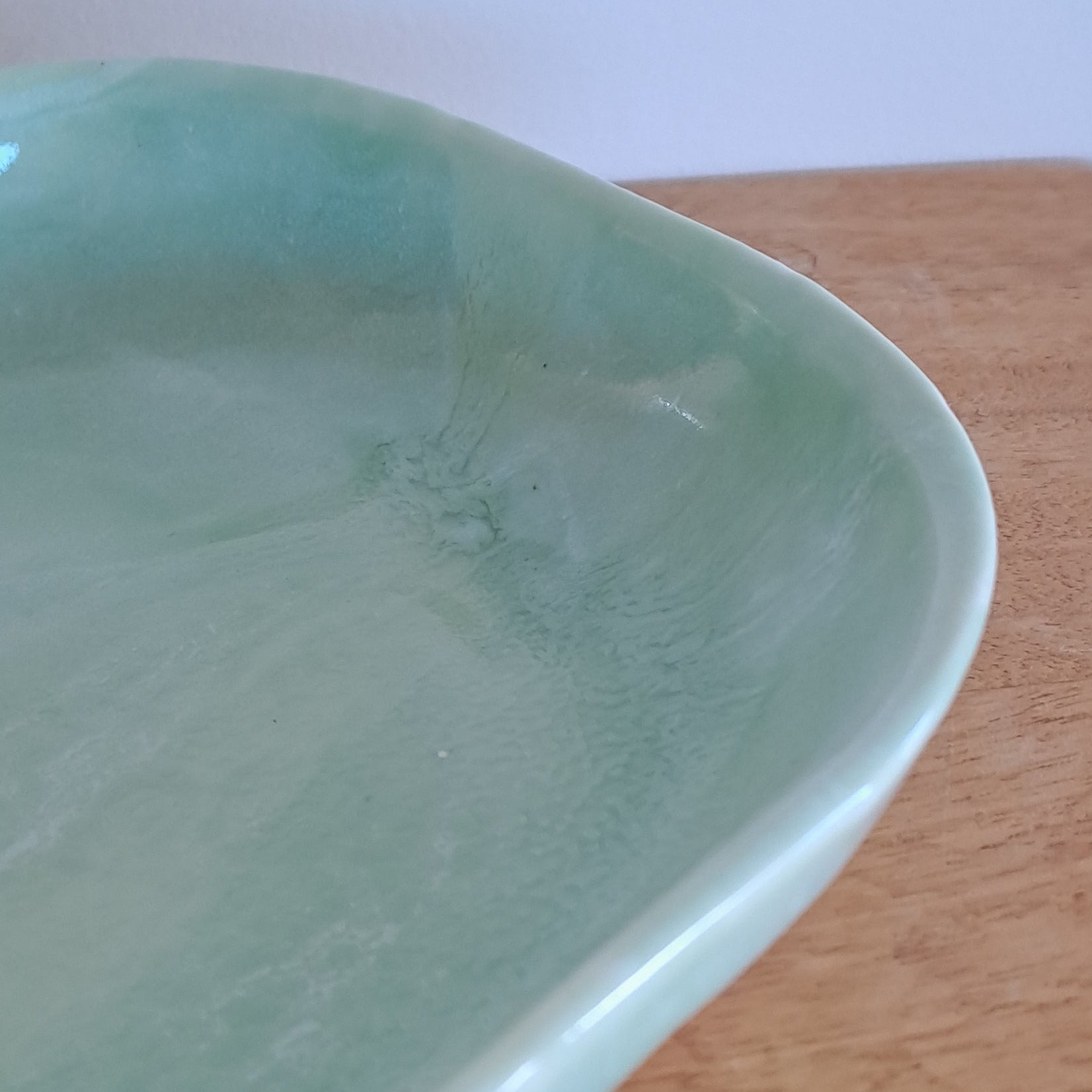 Light green ceramic dish on a wooden surface