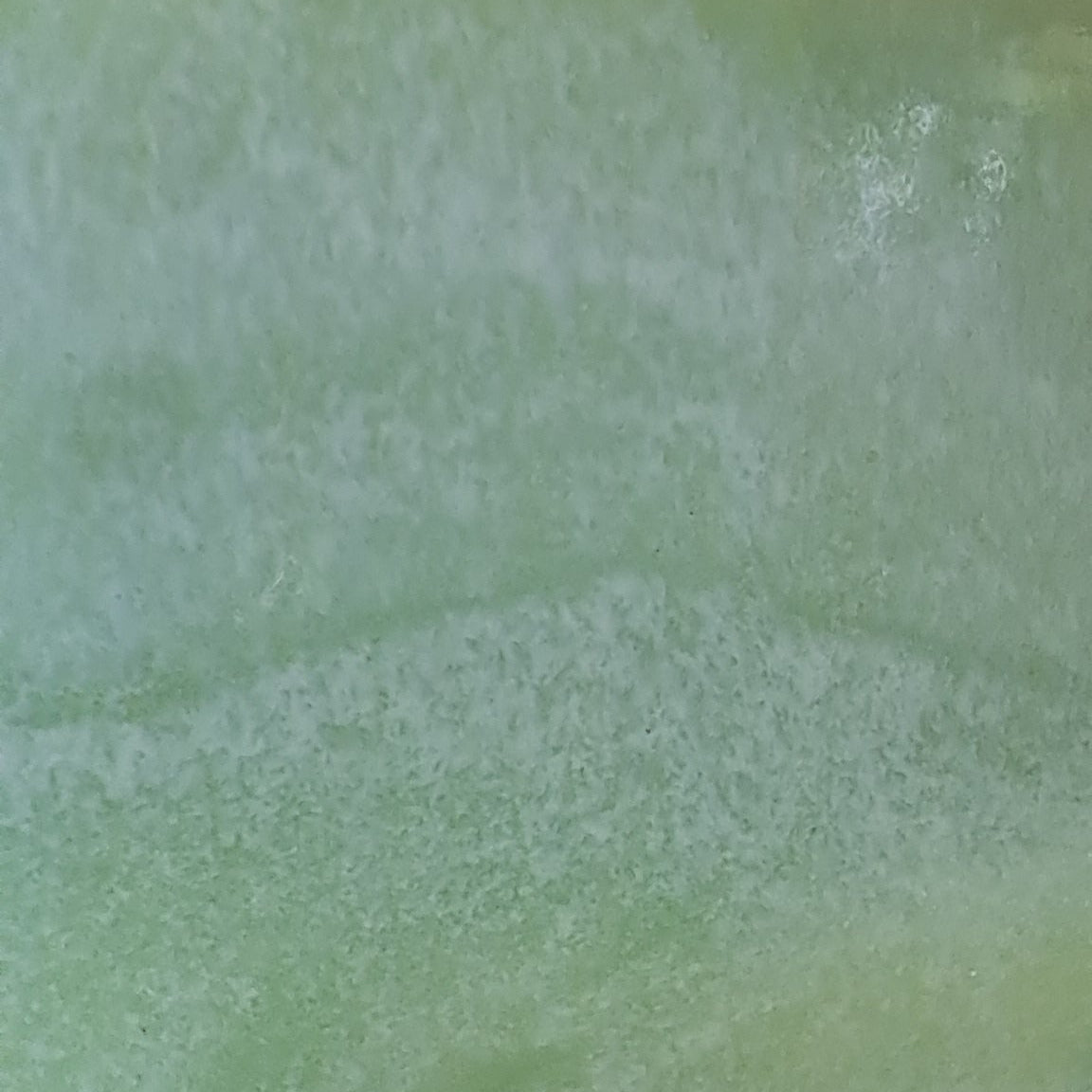 Close-up of a Green ceramic platter on a wooden surface with a white background
