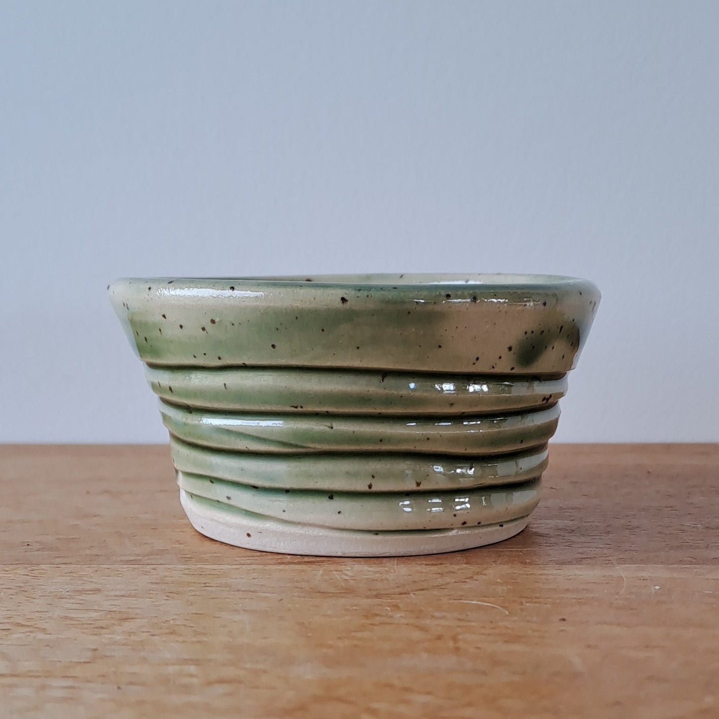 Ceramic bowl with striped design on a wooden surface