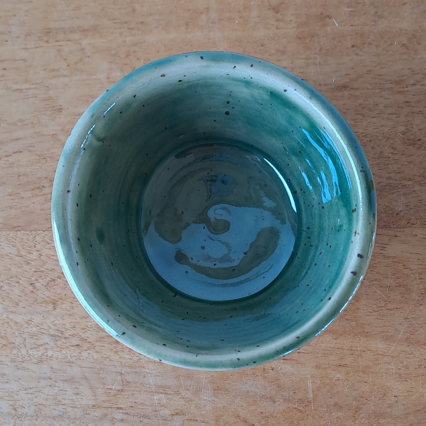 Green ceramic bowl on wooden background