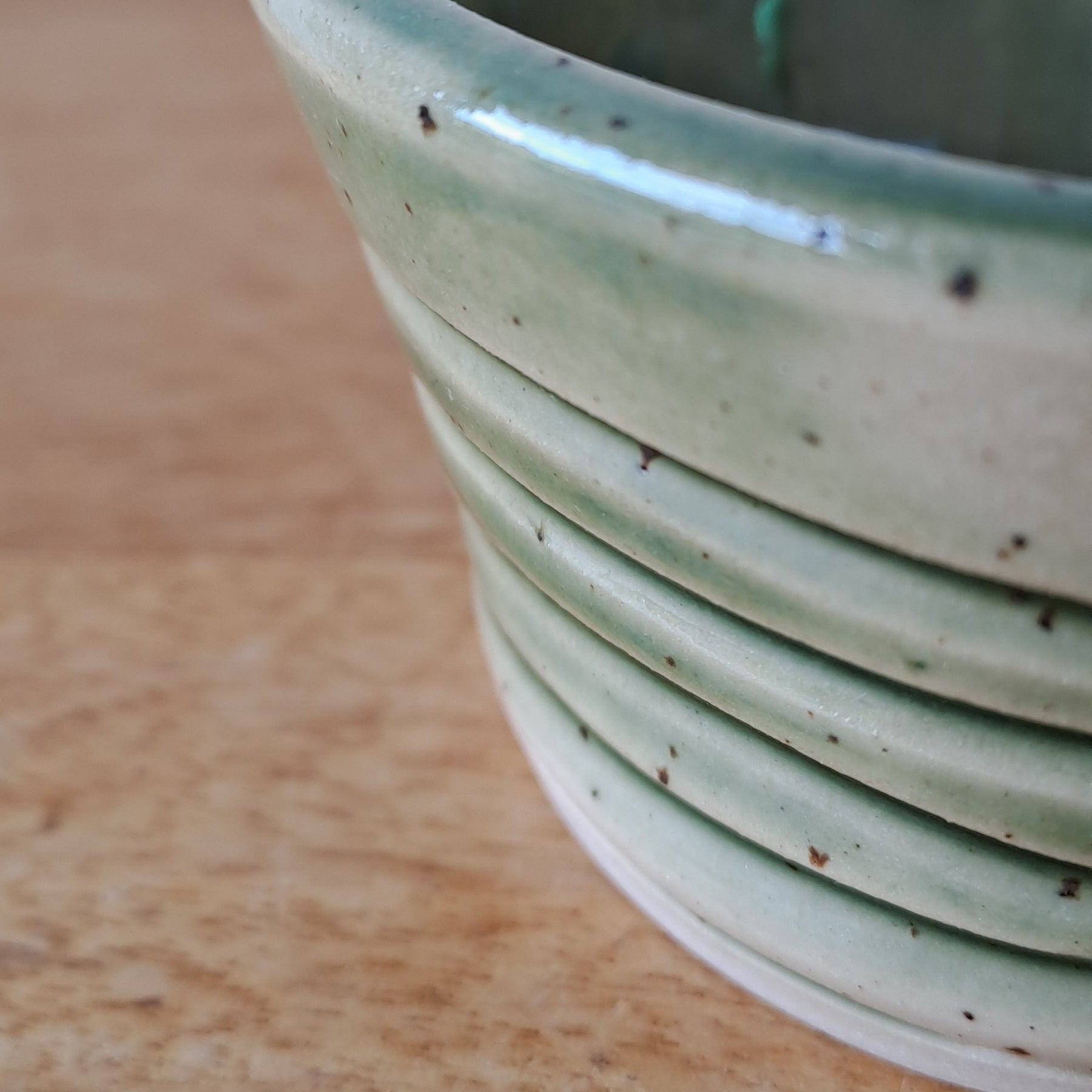 Green ceramic bowl on a wooden surface